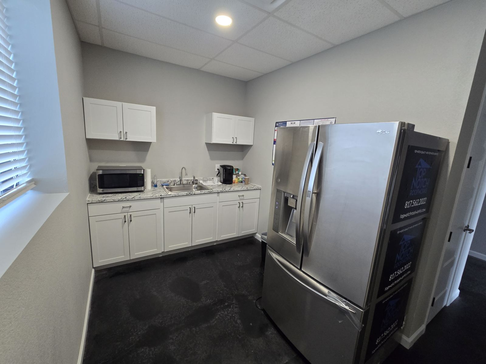 Break room with cabinets and refrigerator